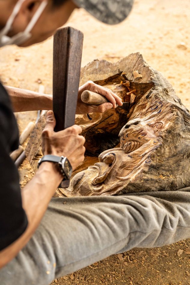 Local artisan sculpts into upcycled driftwood to create artistic masterpiece at Lang Cui Lu Driftwood Village in Hoi An, Vietnam