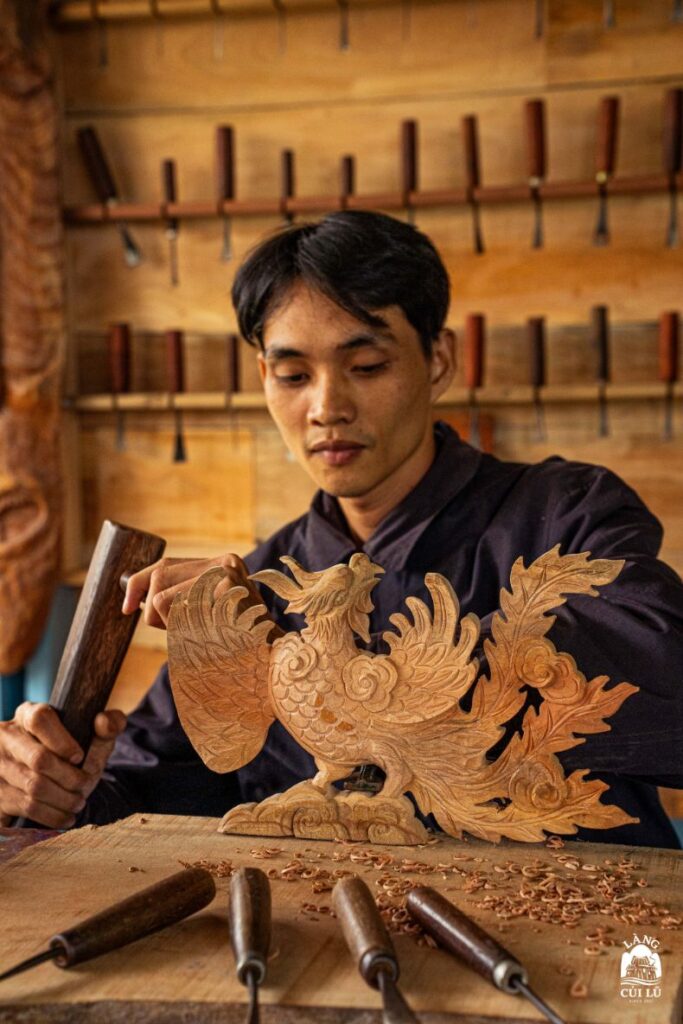 Skilled Vietnamese wood carver working on a sculpture at Lang Cui Lu – Driftwood Village.