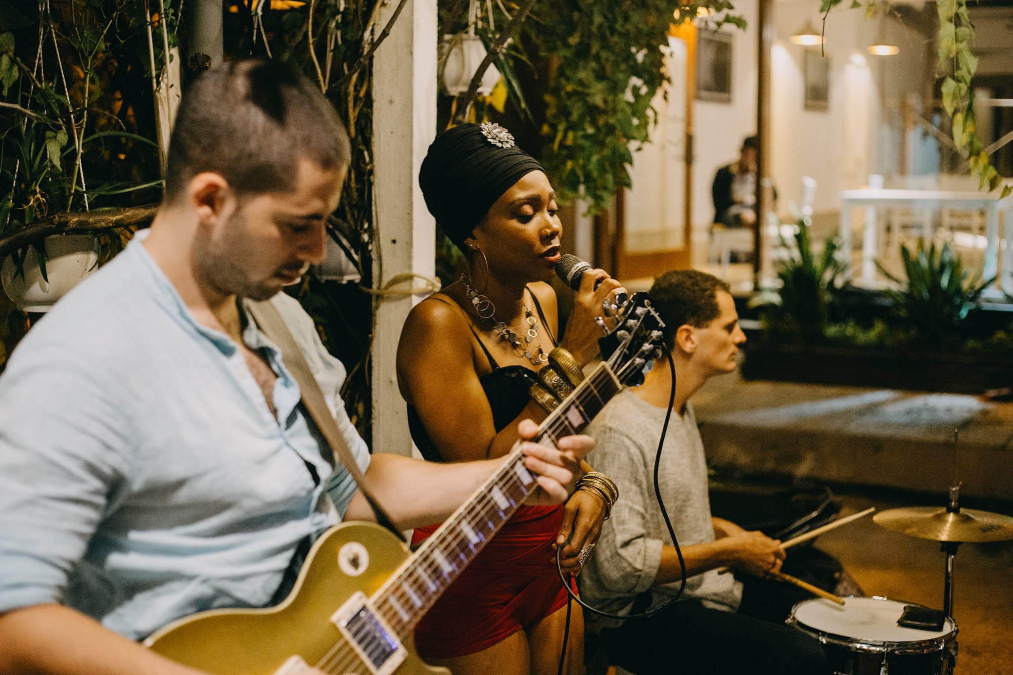 Alt text: Two musicians performing live on stage at Shore Club, An Bang Beach, with the ocean and sunset in the background, creating a vibrant and relaxing atmosphere.