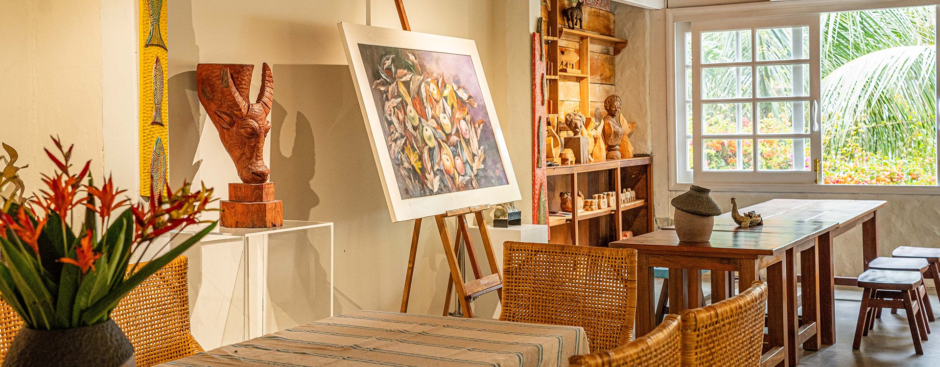 Bright, colorful Vietnamese paintings on display inside Cui Lu Art Space in Hoi An, featuring local artists' works in a modern gallery setting.